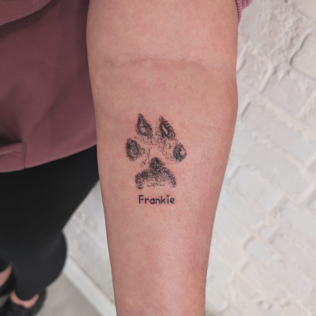 IMG_20250415_073325_710 Script "Frankie" paw print arm tattoo by Leanne at Kimmer Ink Tattoo Studio in Eastleigh, Hampshire.
