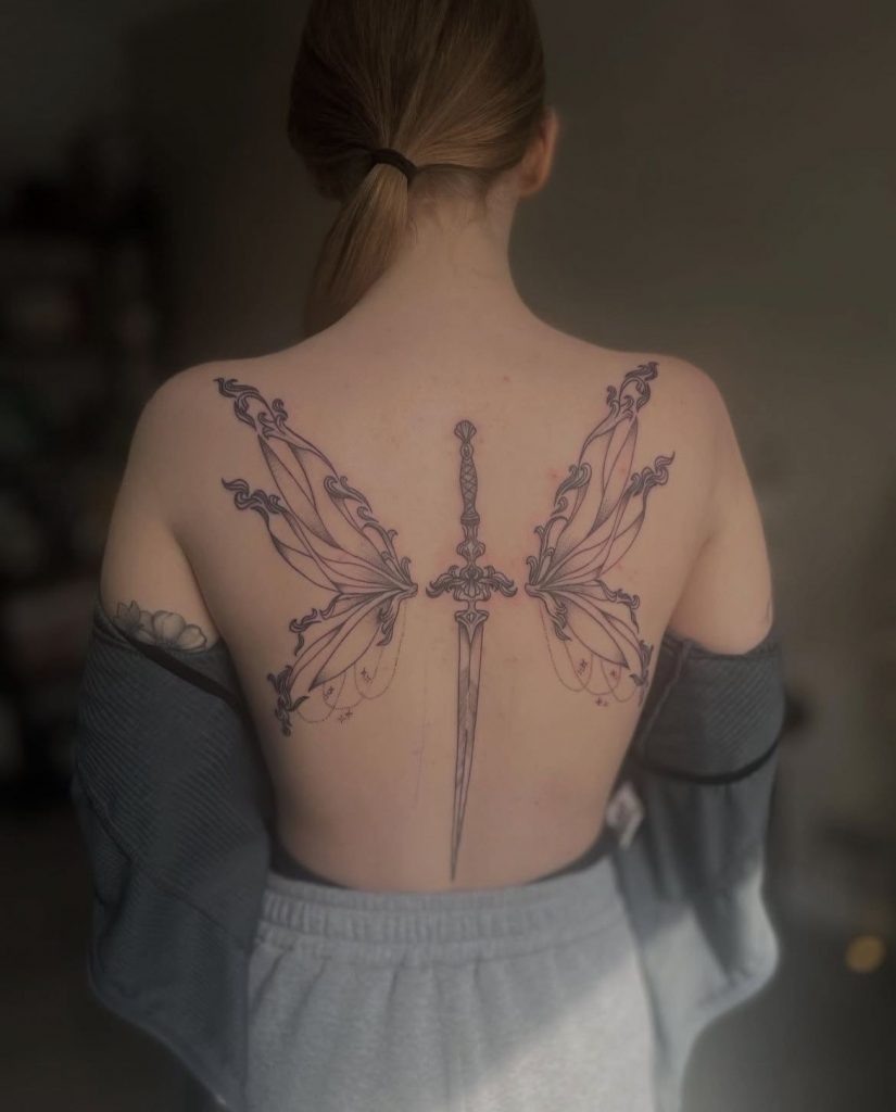 b7ed3a23-ffdf-4b95-8c6d-e41dc04bf0e1 Illustrative fairy wings spine tattoo by Loren at Kimmer Ink Tattoo Studio in Eastleigh, Hampshire.